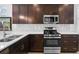 Bright kitchen featuring granite countertops, dark cabinetry, stainless steel appliances, and tile backsplash at 1374 Red Clover Ln, Deland, FL 32724
