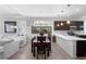 Bright open-concept living area with tile floors, modern lighting, dining area, and stainless steel kitchen appliances at 1374 Red Clover Ln, Deland, FL 32724