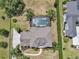 Aerial view of the home features a backyard screened pool, complemented by lush greenery and well-manicured landscaping at 1420 Shady Meadow Ln, Deland, FL 32724