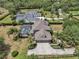 Aerial view showcasing a well-maintained home with three-car garage, mature landscaping, and a spacious driveway at 1420 Shady Meadow Ln, Deland, FL 32724