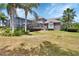 Spacious backyard features tropical landscaping, tall palm trees, and screened-in porch at 1420 Shady Meadow Ln, Deland, FL 32724