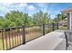 Relaxing balcony with black metal railing overlooks manicured green space and lush trees at 1420 Shady Meadow Ln, Deland, FL 32724