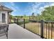 Relaxing balcony with black metal railing overlooks lush green space with trees and blue skies at 1420 Shady Meadow Ln, Deland, FL 32724