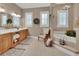 Bathroom boasts a soaking tub, chandelier lighting, double vanity, and shuttered windows at 1420 Shady Meadow Ln, Deland, FL 32724