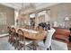 Sophisticated dining area featuring wood table, upholstered chairs, a stunning chandelier, and hardwood floors leading to a staircase at 1420 Shady Meadow Ln, Deland, FL 32724