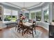 Dining room with large windows providing a scenic view, hardwood floors, and a stylish chandelier at 1420 Shady Meadow Ln, Deland, FL 32724