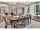 Elegant dining room with coffered ceiling and crystal chandelier, showcases neutral tones, wood table and chairs, and windows with decorative curtains at 1420 Shady Meadow Ln, Deland, FL 32724