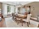 Formal dining room boasts a large wood table, chairs, wood floors, china cabinet, and abundant natural light from large windows at 1420 Shady Meadow Ln, Deland, FL 32724