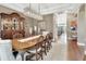 Refined dining room has beautiful hardwood floors, designer lighting fixture, furniture, and decor, with an open view to other living spaces at 1420 Shady Meadow Ln, Deland, FL 32724