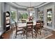 Elegant dining room with large windows providing a scenic view and a stylish chandelier at 1420 Shady Meadow Ln, Deland, FL 32724
