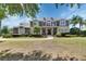 Stately two-story home with a balcony, stone accents, lush lawn and mature trees at 1420 Shady Meadow Ln, Deland, FL 32724