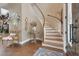 Warm and inviting entry foyer with a curved staircase, hardwood floors, a decorative rug, and charming decorative accents and details at 1420 Shady Meadow Ln, Deland, FL 32724