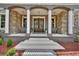 Elegant entrance with double doors, white pillars, and stone accents create a welcoming facade at 1420 Shady Meadow Ln, Deland, FL 32724