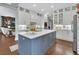 Elegant kitchen features a center island, quartz countertops, white cabinets, stainless steel appliances and hardwood flooring throughout at 1420 Shady Meadow Ln, Deland, FL 32724
