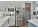 Bright kitchen with white cabinets, stainless steel appliances, and a stylish chevron backsplash at 1420 Shady Meadow Ln, Deland, FL 32724