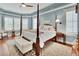 Cozy primary bedroom with four-poster bed, bay windows, and elegant decor at 1420 Shady Meadow Ln, Deland, FL 32724