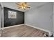 Bedroom with dark accent wall, ceiling fan, and wood-look flooring at 150 Reef Rd, South Daytona, FL 32119
