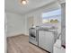 Bright laundry room with wood floors, stainless steel washer and dryer, and a window at 150 Reef Rd, South Daytona, FL 32119