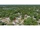 Aerial view of a single-story home surrounded by trees in a neighborhood with a lake in the distance at 1598 Montgomery Ave, Daytona Beach, FL 32117