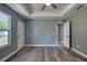 Bedroom with tray ceiling, ceiling fan, and wood-look flooring at 1598 Montgomery Ave, Daytona Beach, FL 32117