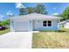 Charming, light blue single-story home featuring an attached garage and well-maintained landscaping at 1598 Montgomery Ave, Daytona Beach, FL 32117