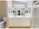 Bathroom featuring double sinks, and a glass shower with vanity lights at 161 Blue Heron Dr # C, Daytona Beach, FL 32119