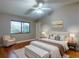 Bright bedroom features a ceiling fan, wood floors, and a large window with natural light at 161 Blue Heron Dr # C, Daytona Beach, FL 32119