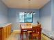 Dining room with wood table, chairs, cabinet, and lots of natural light from the window at 161 Blue Heron Dr # C, Daytona Beach, FL 32119