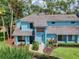 View of the home with lush tropical landscaping and a tiled roof at 161 Blue Heron Dr # C, Daytona Beach, FL 32119