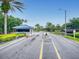 Entrance to Pelican Bay community, featuring a guard house, mature landscaping, and a lake view at 161 Blue Heron Dr # C, Daytona Beach, FL 32119