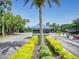 Community guard house entrance with well manicured landscaping and a red car parked at the entrance at 161 Blue Heron Dr # C, Daytona Beach, FL 32119