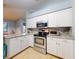 Updated kitchen features stainless steel appliances, stone countertops, and white cabinets at 161 Blue Heron Dr # C, Daytona Beach, FL 32119