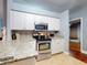 Updated kitchen features stainless steel appliances, stone countertops, and white cabinets at 161 Blue Heron Dr # C, Daytona Beach, FL 32119