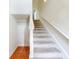Carpeted staircase with white railing, adjacent to tiled flooring, in a bright home at 161 Blue Heron Dr # C, Daytona Beach, FL 32119