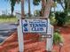 Pelican Bay Tennis Club welcomes visitors in a rustic sign against a backdrop of trees and greenery at 161 Blue Heron Dr # C, Daytona Beach, FL 32119