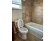 Bathroom features a tiled shower and tub, toilet, and window at 1649 Courtland Blvd, Deltona, FL 32738