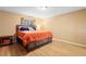 Bedroom features wood-look flooring, a large bed with an orange comforter, and neutral-colored walls at 1731 Urbana Ave, Deltona, FL 32725