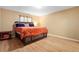 Bedroom features wood-look flooring, a large bed with an orange comforter, and neutral-colored walls at 1731 Urbana Ave, Deltona, FL 32725