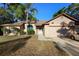 Inviting single-story brick home featuring an attached garage, manicured shrubs, and a lovely palm tree in the front yard at 1731 Urbana Ave, Deltona, FL 32725