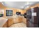 Bright kitchen with wood cabinets, black appliances, tile flooring, and ample counter space at 1731 Urbana Ave, Deltona, FL 32725