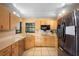 Well-lit kitchen featuring wooden cabinets, stainless steel refrigerator, and tile flooring at 1731 Urbana Ave, Deltona, FL 32725