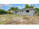 Backyard view features a house with a green roof, a grey exterior, and scattered grass at 1808 Green Pl, Ormond Beach, FL 32174