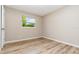 Cozy bedroom featuring wood-look flooring and a window offering a view of lush greenery at 1808 Green Pl, Ormond Beach, FL 32174