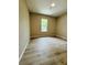 Cozy bedroom featuring sleek wood flooring and natural light from the window at 1808 Green Pl, Ormond Beach, FL 32174