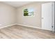Well-lit bedroom with wood-look flooring, a window view, and a fresh, neutral color palette at 1808 Green Pl, Ormond Beach, FL 32174