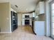 Modern kitchen featuring stainless steel appliances, white cabinets, and tiled floors for a stylish and functional cooking space at 1808 Green Pl, Ormond Beach, FL 32174