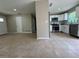 Open-concept layout showcasing the kitchen with stainless steel appliances, white cabinets, and seamless flow to the living area at 1808 Green Pl, Ormond Beach, FL 32174