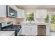 Modern kitchen featuring white cabinets, stainless steel appliances, and a view of the backyard at 1808 Green Pl, Ormond Beach, FL 32174