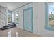 Bright entryway featuring white walls, blue trim, tile floors, a staircase, and a light blue door at 216 Earl St, Daytona Beach, FL 32118