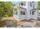 An exterior side view of a white home with a textured finish and stone sidewalk at 216 Earl St, Daytona Beach, FL 32118